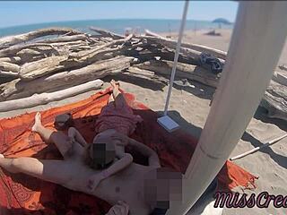 Denne exhibitionist lærer milf giver en dristig udendørs håndjob på en offentlig nøgen strand til en stor pik