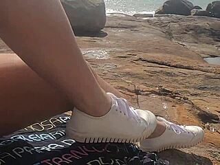 Uma linda novinha é observada fazendo sexo em público nas pedras da praia e é atrapalhado por um terceiro indivíduo