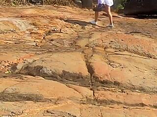 Uma linda novinha é observada fazendo sexo em público nas pedras da praia e é atrapalhado por um terceiro indivíduo