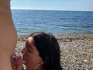 Petite mignonne caresse une énorme bite sur une plage publique