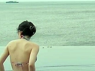 Stunning Asian college princess with ponytail shows off legs at infinity pool. Her small waist and beautiful feet shine by the water.