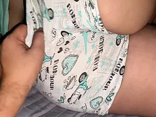 Korpig mogen styrmor slappar på sängen medan styyson delar hemmaknull