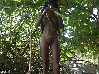 naked skinny tribe woman making a bow to go hunting