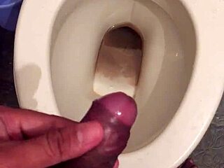 she squats low letting her monster cock drip cum while peeing nice and steady