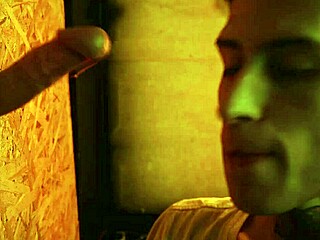 Twink performs blowjob through glory hole