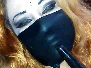 Face mask covers mouth during black dildo bondage and masturbation.