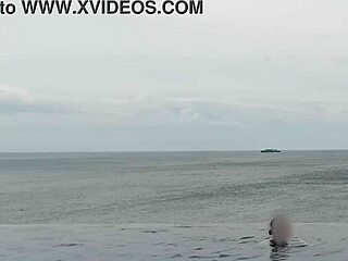 Stunning Asian college princess with ponytail shows off legs at infinity pool. Her small waist and beautiful feet shine by the water.