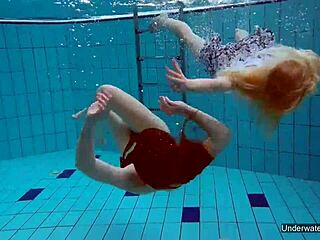 שתי לסביות מגולחות חמות מנשקות ומגעמות מתחת למים בבריכה