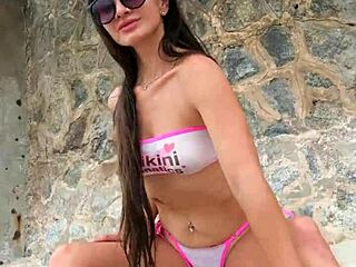 Brunette babe flashes bikini ass on crowded beach outdoors