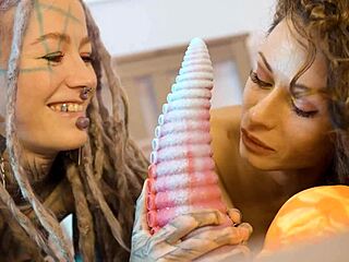 Neon fishnets hide nothing as lesbians gape asses with massive anal toys